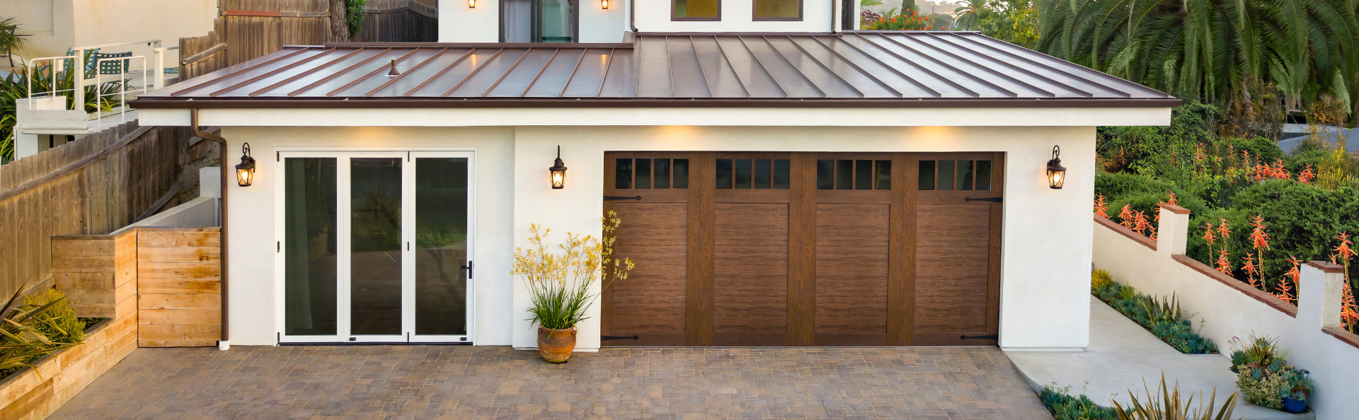 white house with brown metal roof and brown wood look garage door with windows